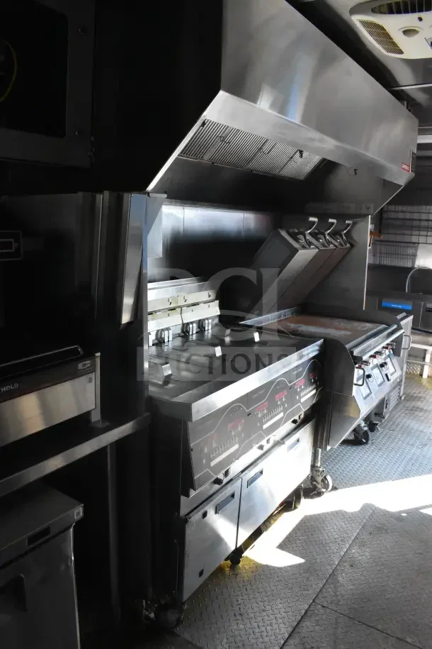 2021 Rock Solid Cargo 8.5'x28' food trailer interior with CaptiveAire hood, fire suppression, Taylor milkshake machine, and grill.