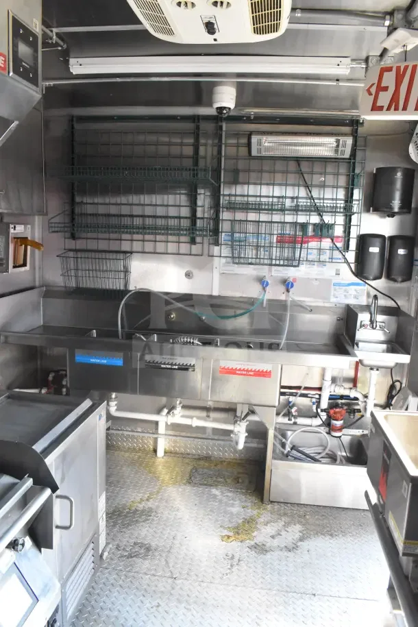 2021 Rock Solid Cargo 8.5'x28' food trailer interior with stainless steel CaptiveAire hood, sinks, and refrigeration suite.