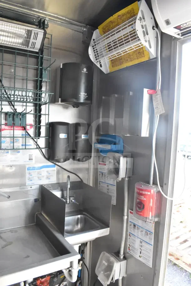 2021 Rock Solid Cargo 8.5'x28' food trailer interior with sink, CaptiveAire hood, hand sanitizer dispensers, and fire suppression system.