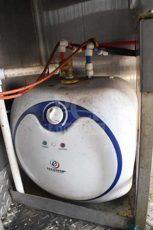 'Eccotemp' branded water heater inside 2021 Rock Solid Cargo 8.5'x28' food trailer. Features power and heating indicators.