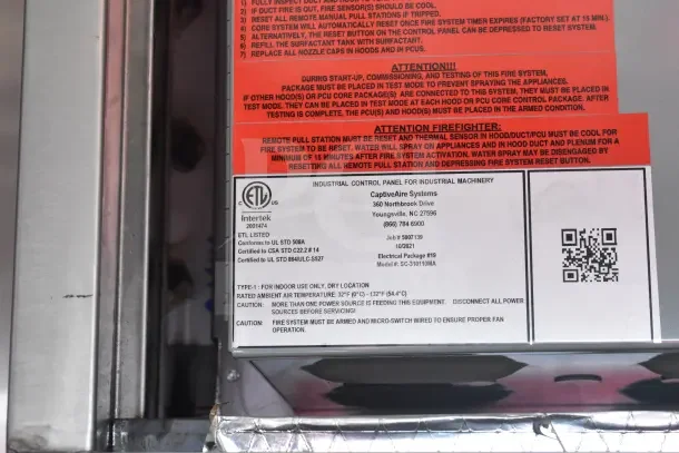 CaptiveAire Systems industrial control panel label on 2021 Rock Solid Cargo food trailer. Includes safety warnings and specifications.