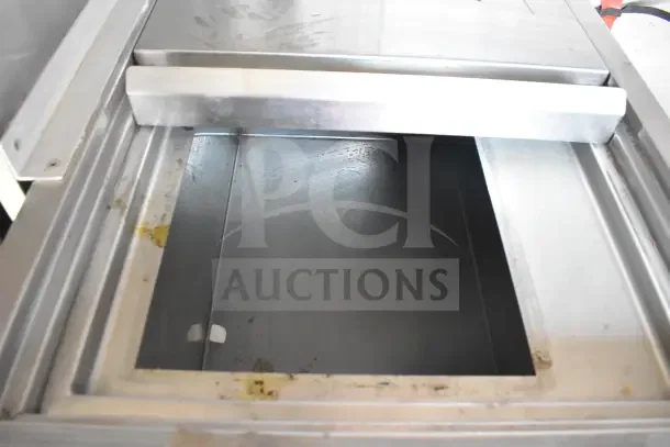 Interior view of 2021 Rock Solid Cargo food trailer, featuring a stainless steel compartment. Slight wear visible.