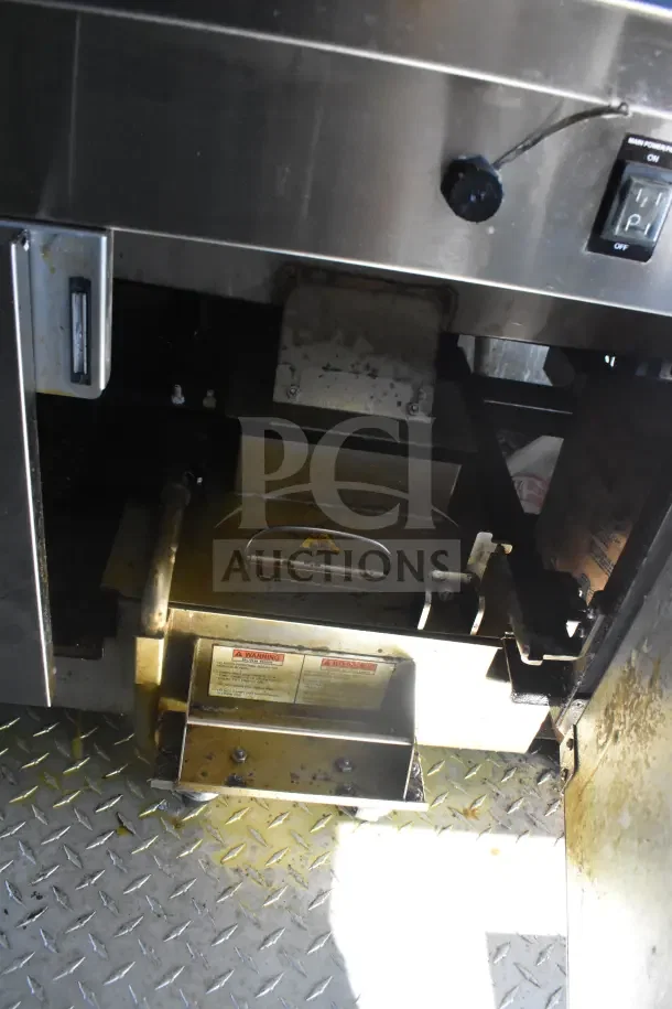 Interior view of 2021 Rock Solid Cargo food trailer showing kitchen equipment, metal surfaces, and visible warning labels.