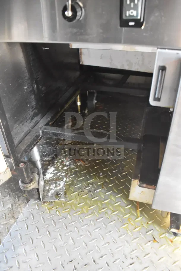 2021 Rock Solid Cargo food trailer interior with CaptiveAire hood, showcasing diamond plate flooring under equipment space.