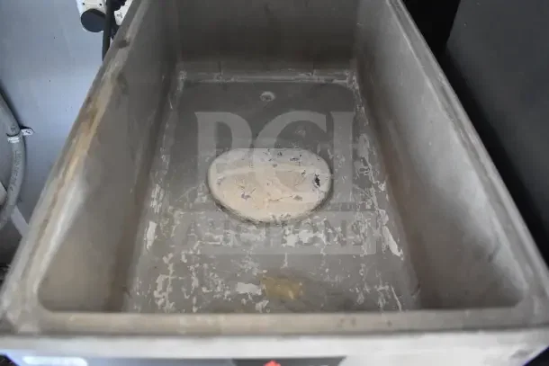 Interior of a stainless steel sink in a 2021 Rock Solid Cargo food trailer, showing wear. Includes CaptiveAire hood setup.