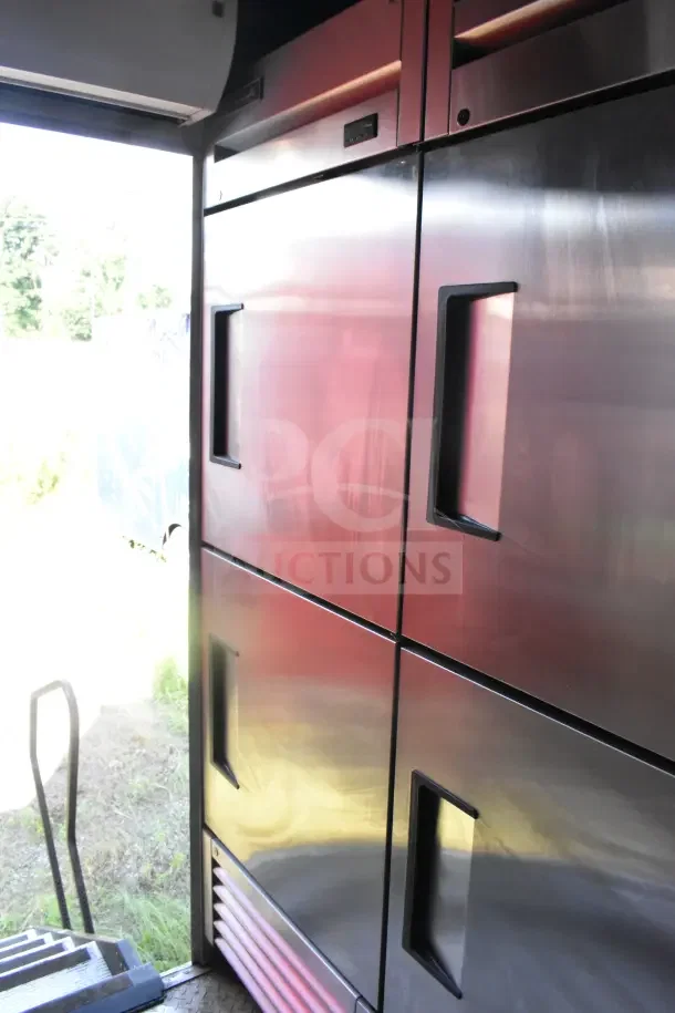 2021 Rock Solid Cargo 8.5'x28' food trailer interior, showcasing stainless steel refrigeration unit and steps.