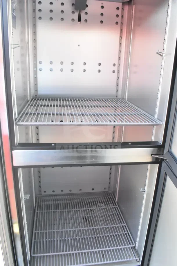 Stainless steel interior of 2021 Rock Solid Cargo food trailer refrigeration suite, featuring wire shelving.