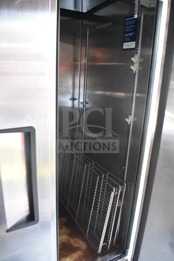 Interior view of 2021 Rock Solid Cargo food trailer refrigeration suite, showing metal shelves and CaptiveAire system components.