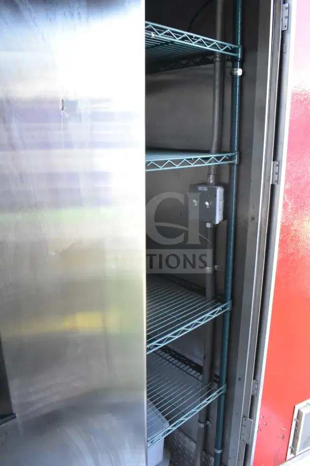 Interior view of a 2021 Rock Solid Cargo 8.5'x28' food trailer, showing stainless steel shelving and part of the refrigeration suite.