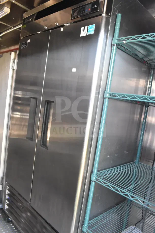 Stainless steel refrigeration unit inside the 2021 Rock Solid Cargo 8.5'x28' food trailer, with visible shelving.