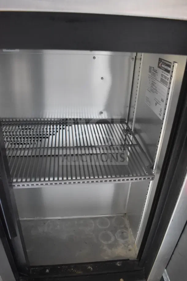 Interior view of refrigeration unit in a 2021 Rock Solid Cargo food trailer. Features metal shelving, CaptiveAire hood, and fire suppression system.