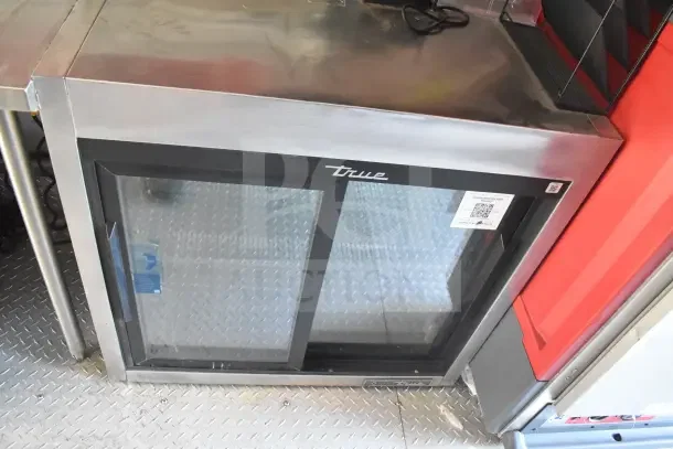 True refrigeration unit in a 2021 Rock Solid Cargo food trailer. Features stainless steel top and diamond plate flooring.