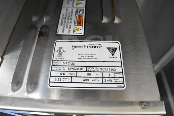 Henny Penny MPC-22 model label, showing 120 volts, 60 Hz, serial number GC2111031, UL-listed cooking appliance.