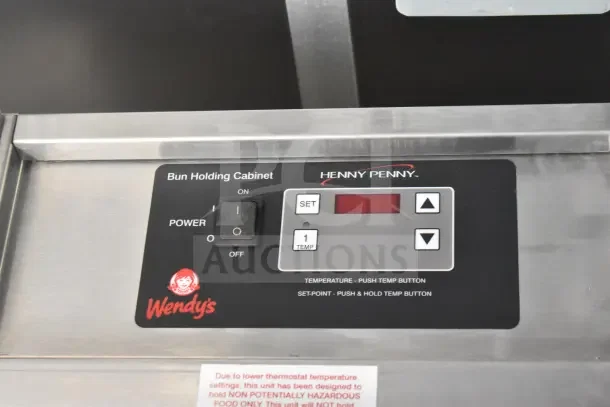 Bun holding cabinet control panel by Henny Penny in a 2021 Rock Solid Cargo food trailer, Wendy's branding visible.