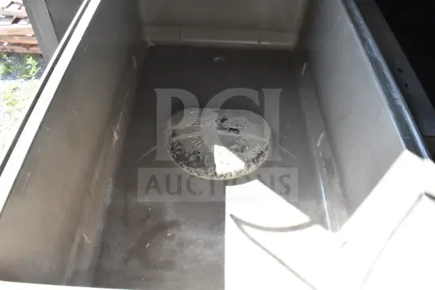 Interior view of a section in a 2021 Rock Solid Cargo food trailer with a worn water cap visible at the bottom.
