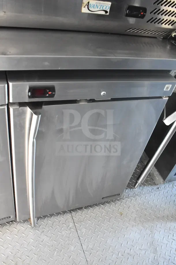 2021 Rock Solid Cargo food trailer interior, featuring Avantco refrigeration unit; visible floor and stainless steel exterior.