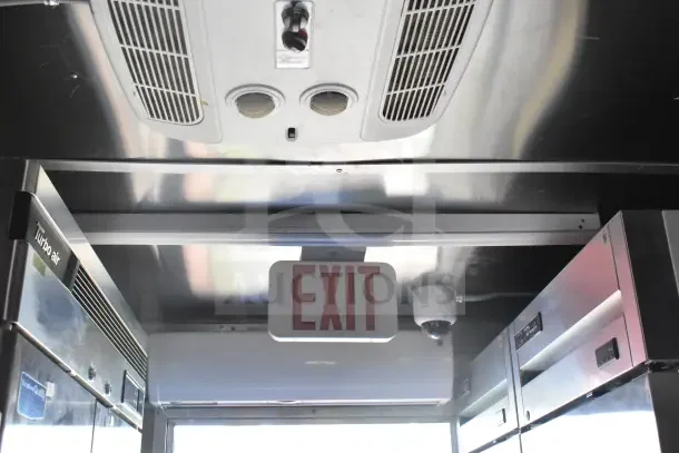 2021 Rock Solid Cargo food trailer interior showing Turbo Air refrigeration, exit sign, and surveillance camera.