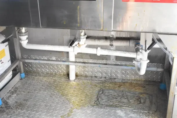 2021 Rock Solid Cargo food trailer interior showing plumbing and diamond plate flooring, indicating setup for kitchen equipment.