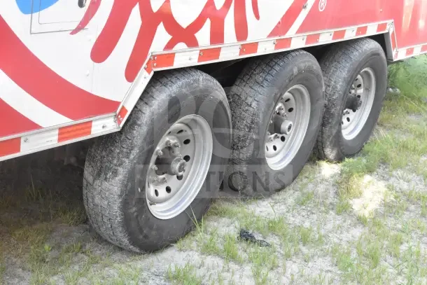 2021 Rock Solid Cargo 8.5'x28' food trailer showing wheels and exterior design with red and white color scheme.