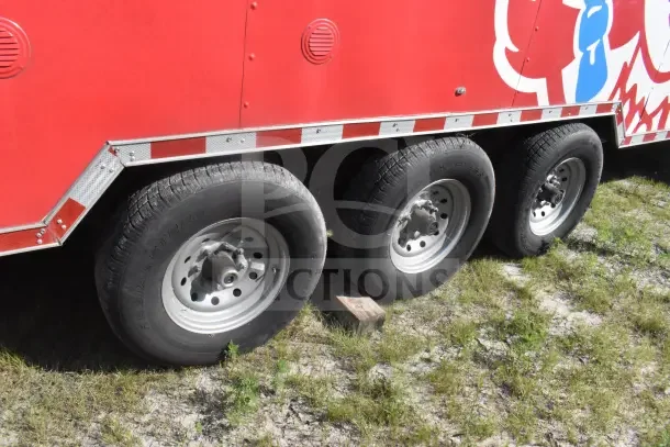 2021 Rock Solid Cargo 8.5'x28' red food trailer showing sturdy tires and exterior condition; includes CaptiveAire hood.