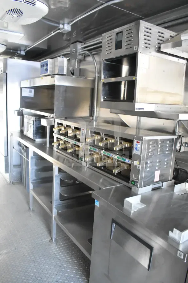 2021 Texino 8.5'x28' food trailer with CaptiveAire grease hood, fire system, refrigeration, and breading tables.