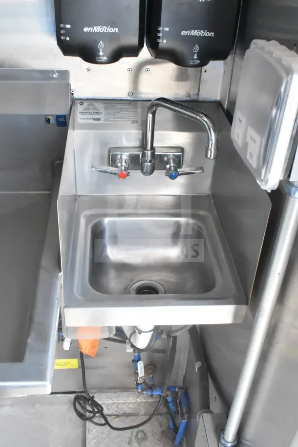 2021 Texino food trailer interior showing a stainless steel sink with dual taps, enMotion dispensers, and visible plumbing.