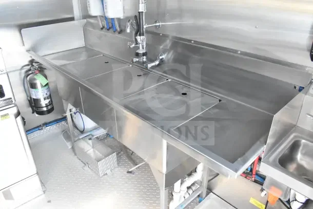 2021 Texino food trailer interior with stainless steel sink, CaptiveAire grease hood, fire suppression system, and refrigeration.