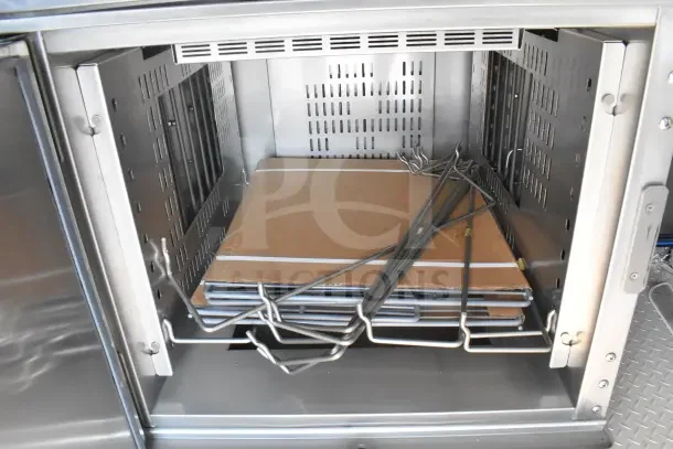 Interior of Texino food trailer showing shelving and metal racks, highlighting storage space and stainless steel construction.