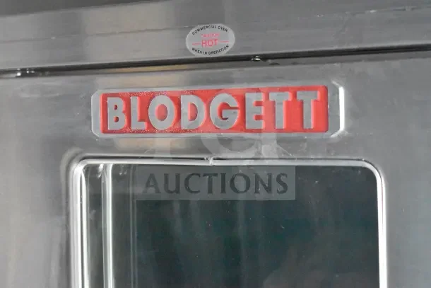 Blodgett oven door with visible commercial oven caution label. Stainless steel finish, slightly dusty condition.