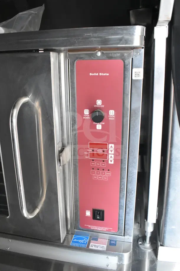 Stainless steel oven control panel with solid state controls, energy efficiency stickers, and American flag label.