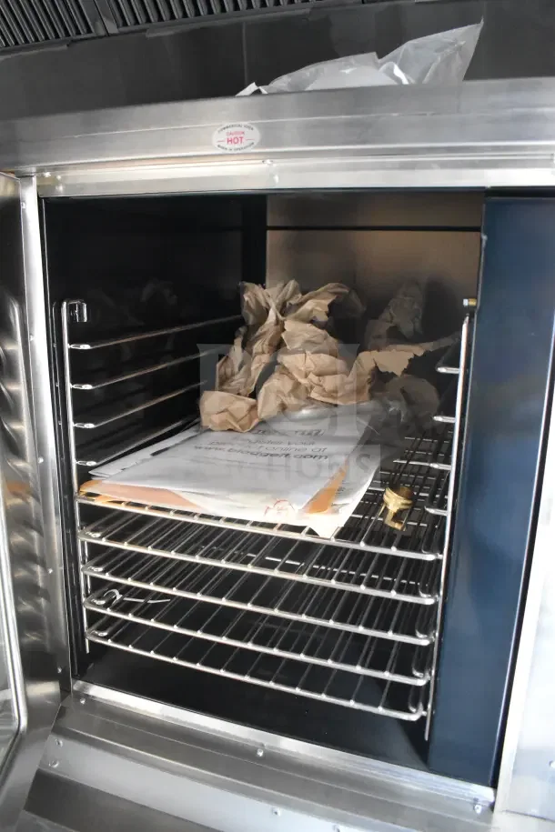 2021 Texino food trailer interior showing multiple metal shelves and papers. Features CaptiveAire grease hood.