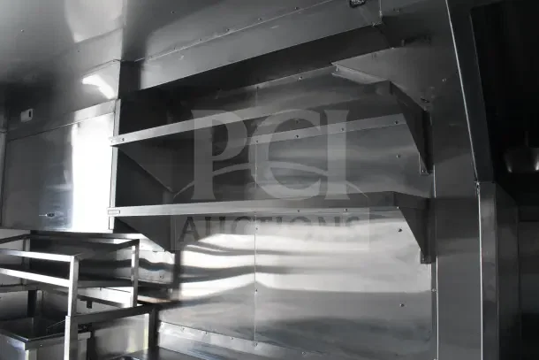 2021 Texino 8.5'x28' food trailer interior; features CaptiveAire grease hood, shelves, and stainless steel surfaces.