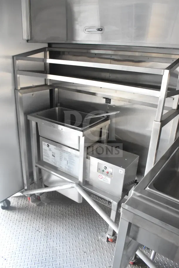2021 Texino 8.5'x28' food trailer interior with stainless steel CaptiveAire grease hood, fryer, and breading tables.