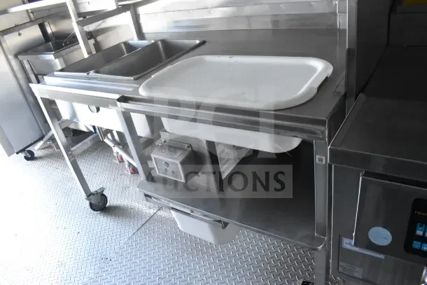 2021 Texino 8.5'x28' food trailer interior, featuring stainless steel breading tables, sinks, and refrigeration units.