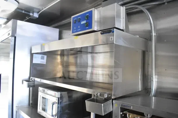 2021 Texino 8.5'x28' food trailer interior with CaptiveAire grease hood, fire suppression system, and stainless steel surfaces.
