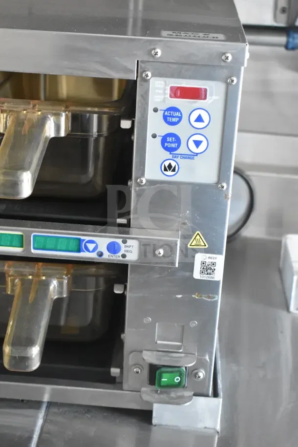 Stainless steel control panel with temperature settings, toggle buttons, QR code, and indicator lights on a Texino food trailer.