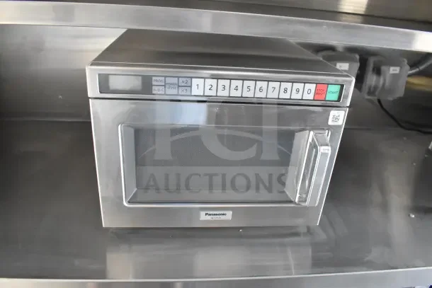 Panasonic NE-17523 microwave in stainless steel, located inside 2021 Texino food trailer, keypad buttons visible.