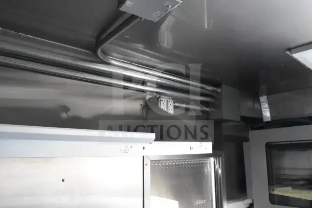2021 Texino 8.5'x28' food trailer interior showing CaptiveAire grease hood and metal piping, pristine condition.