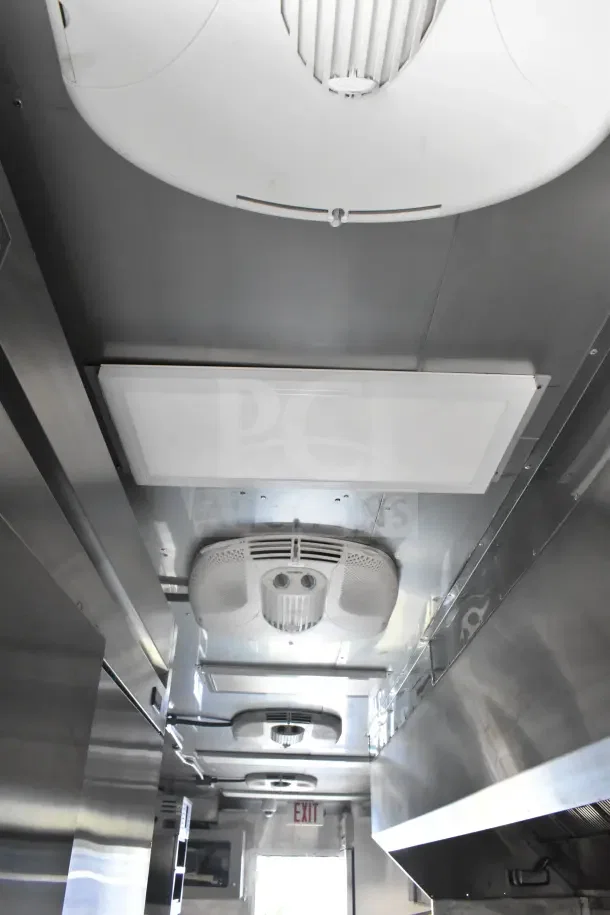 2021 Texino 8.5'x28' food trailer interior, featuring CaptiveAire grease hood, fire suppression system, and refrigeration units.