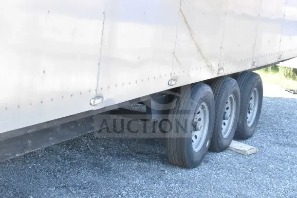 2021 Texino 8.5'x28' food trailer showing triple axle wheels and exterior riveted paneling.
