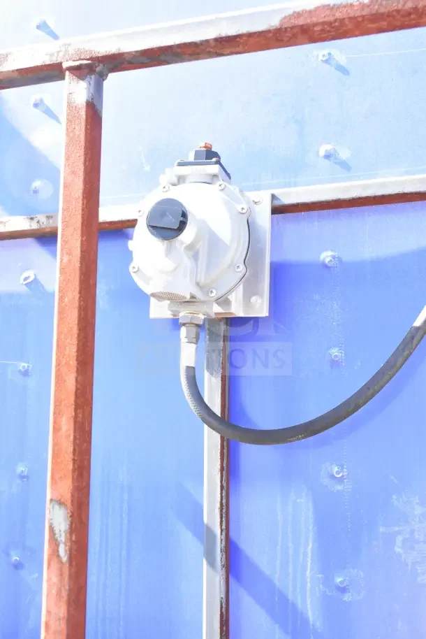 Outdoor view of a utility control box mounted on a blue panel with metal framing, featuring outdoor wiring.