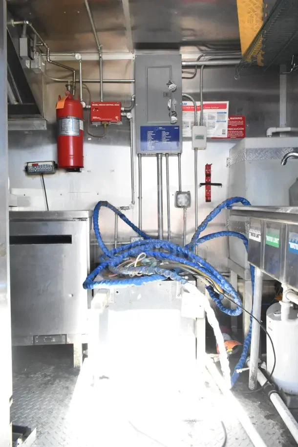 Interior of a 2020 Diamond Cargo 24' Kitchen Trailer with visible wiring, fire extinguisher, and Arctic Air refrigeration components.