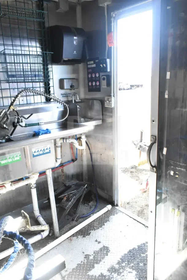 2020 Diamond Cargo 24' commercial kitchen trailer interior with stainless steel sink, plumbing, and paper towel dispenser.