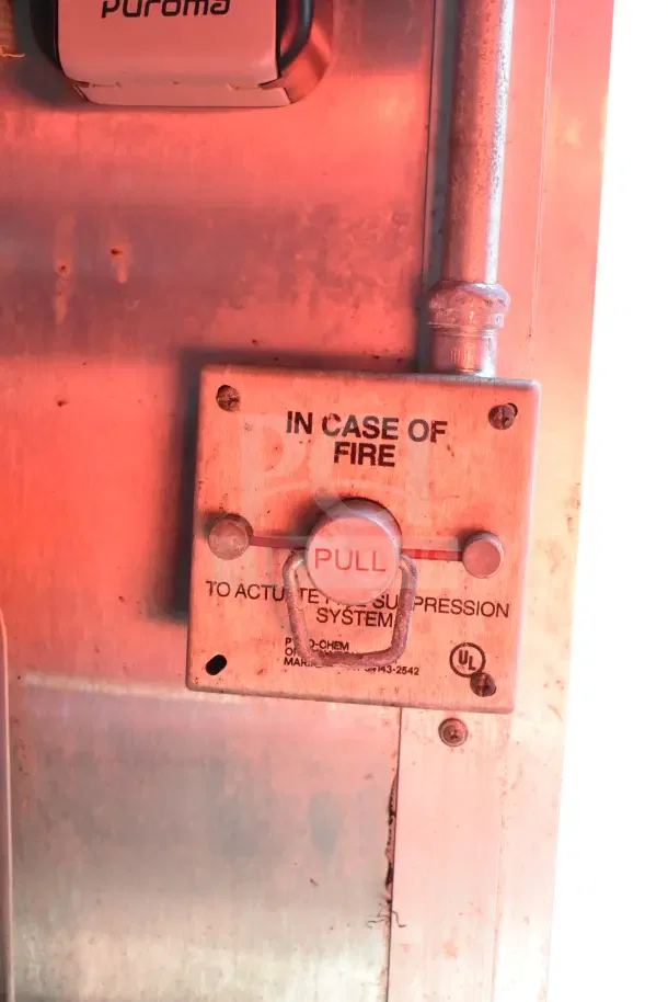 Close-up of a fire suppression system activation pull box in a 2020 Diamond Cargo kitchen trailer, marked for emergency use.