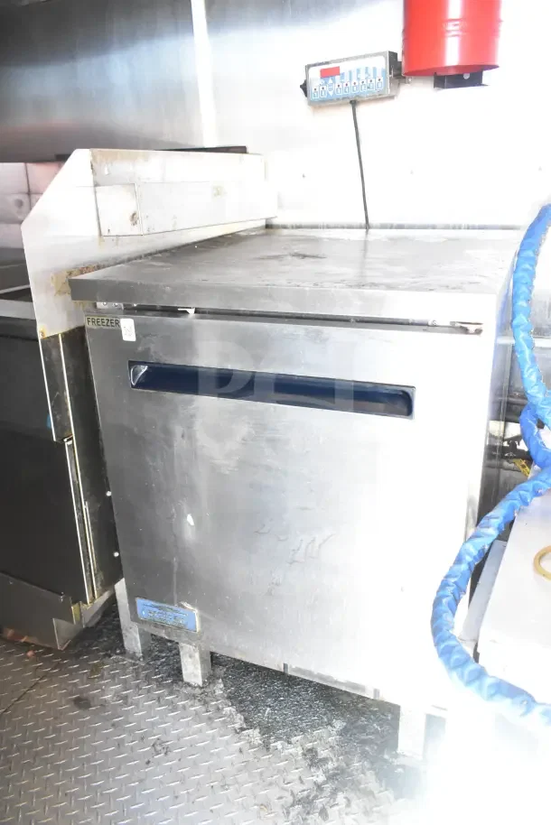 Diamond Cargo 24' kitchen trailer interior showing stainless steel freezer unit and griddle, tested and working condition.