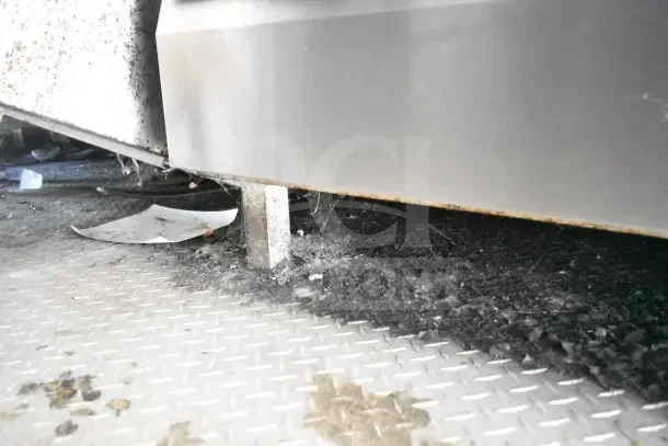 2020 Diamond Cargo 24' kitchen trailer undercarriage with visible support leg and textured flooring. Some dirt and debris present.