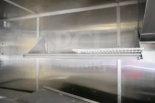 2020 Diamond Cargo 24' commercial kitchen trailer interior with stainless steel walls and shelf.