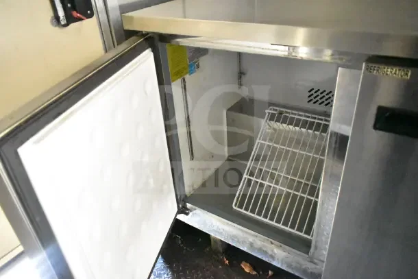 2020 Diamond Cargo 24' kitchen trailer interior showing open Arctic Air refrigeration unit with wire shelf and clean interior.