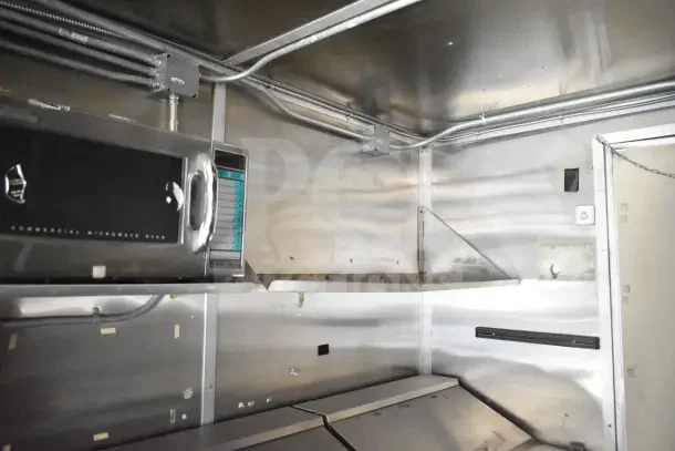 2020 Diamond Cargo 24' commercial kitchen trailer interior with stainless steel surfaces and commercial microwave oven.
