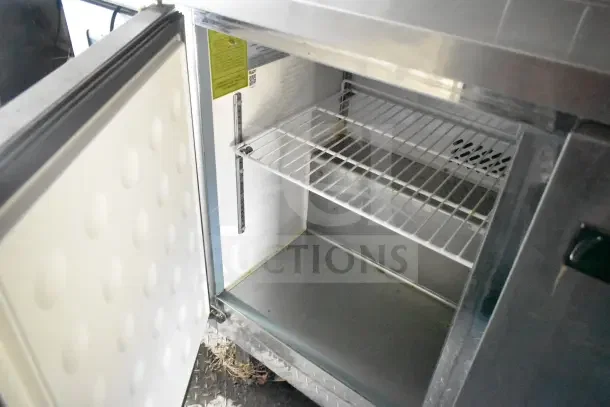 Open Arctic Air refrigeration unit inside a 2020 Diamond Cargo kitchen trailer, showing wire shelves and interior label.
